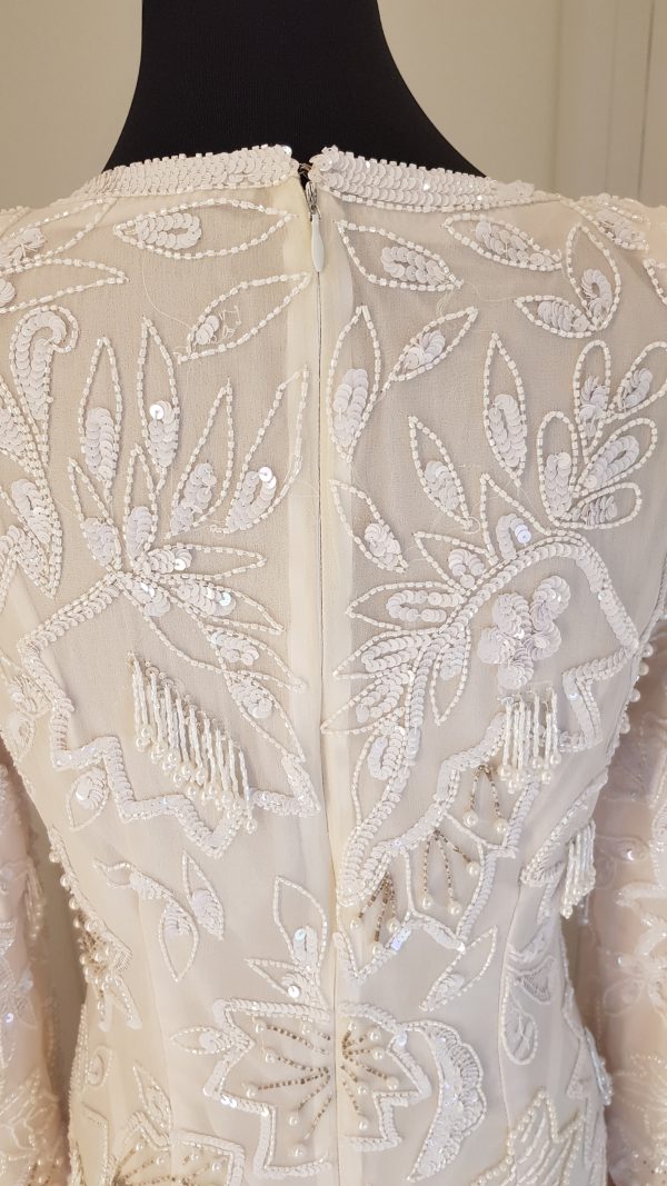 weißes, edles Braut- oder Ballkleid mit Perlen- und Pailettenstickerei mit spitzen Schultern, lange Ärmel, bodenlang mit seitlichem Gehschlitz