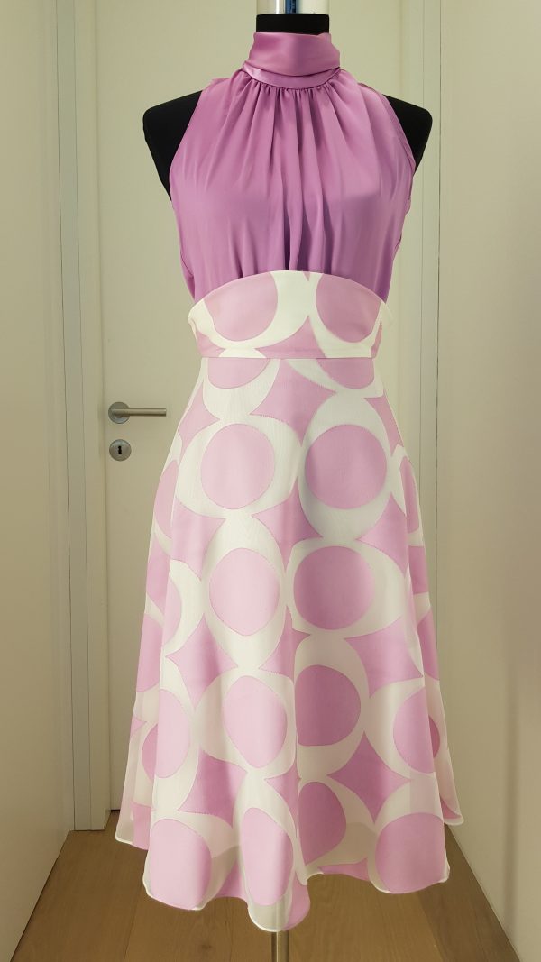 Edle, ärmellose lila Seidenbluse mit hohem engen Schalkragen und Schluppe im Nacken, Rock mit konischem Bund, geometrisches Muster, weit schwingender Rock