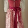Offizielles "Pink Ribbon" Dirndl von Sportalm, rosa Leinenleib mit Froschgoscherl, edlen Silberknöpfen mit Rosenmotiv, rosa Rock mit Blumenmuster, mit hochgeschlossener weißen Spitzenbluse, Schürze weiß mit rosa Paisleymuster und pinkem Schürzenbank mit Strasssteinen