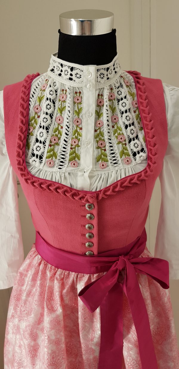 Offizielles "Pink Ribbon" Dirndl von Sportalm, rosa Leinenleib mit Froschgoscherl, edlen Silberknöpfen mit Rosenmotiv, rosa Rock mit Blumenmuster, mit hochgeschlossener weißen Spitzenbluse, Schürze weiß mit rosa Paisleymuster und pinkem Schürzenbank mit Strasssteinen