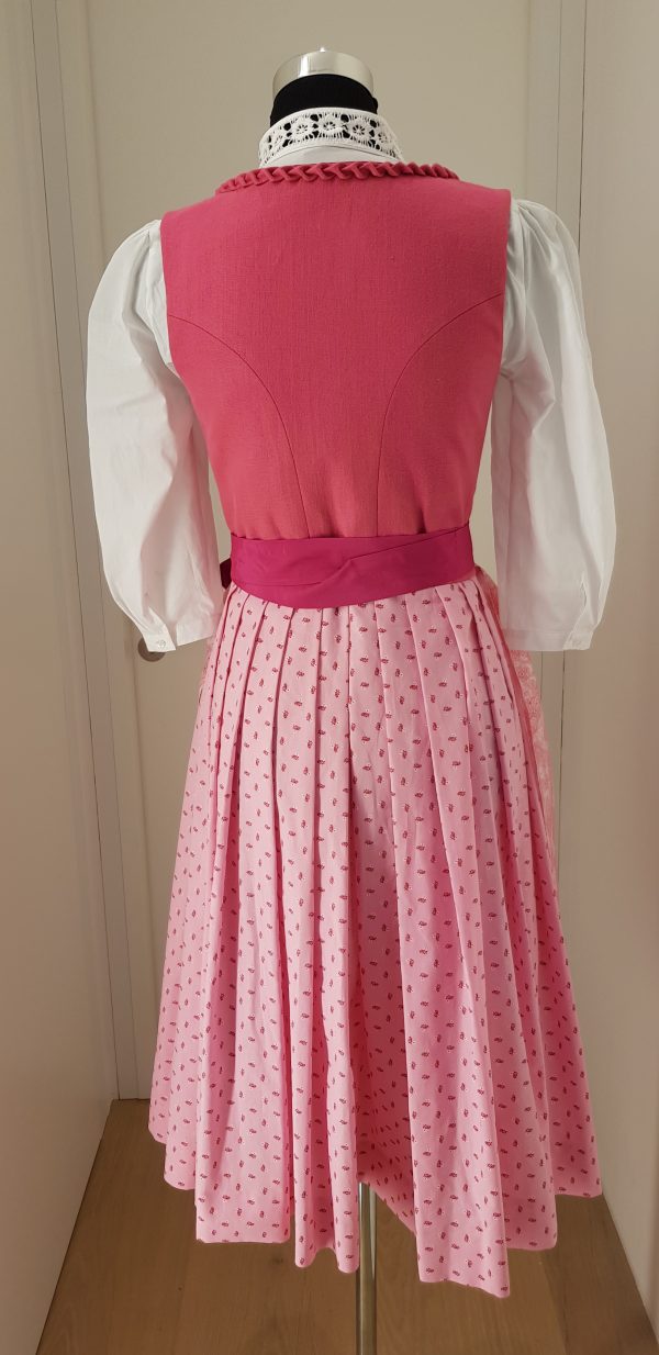 Offizielles "Pink Ribbon" Dirndl von Sportalm, rosa Leinenleib mit Froschgoscherl, edlen Silberknöpfen mit Rosenmotiv, rosa Rock mit Blumenmuster, mit hochgeschlossener weißen Spitzenbluse, Schürze weiß mit rosa Paisleymuster und pinkem Schürzenbank mit Strasssteinen