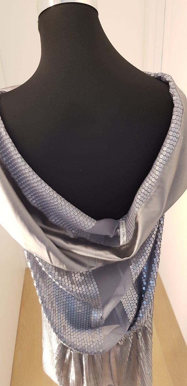 Silbernes Paillettenkleid mit extrem breitem silbernen Schalkragen, blaues Ornament vorne