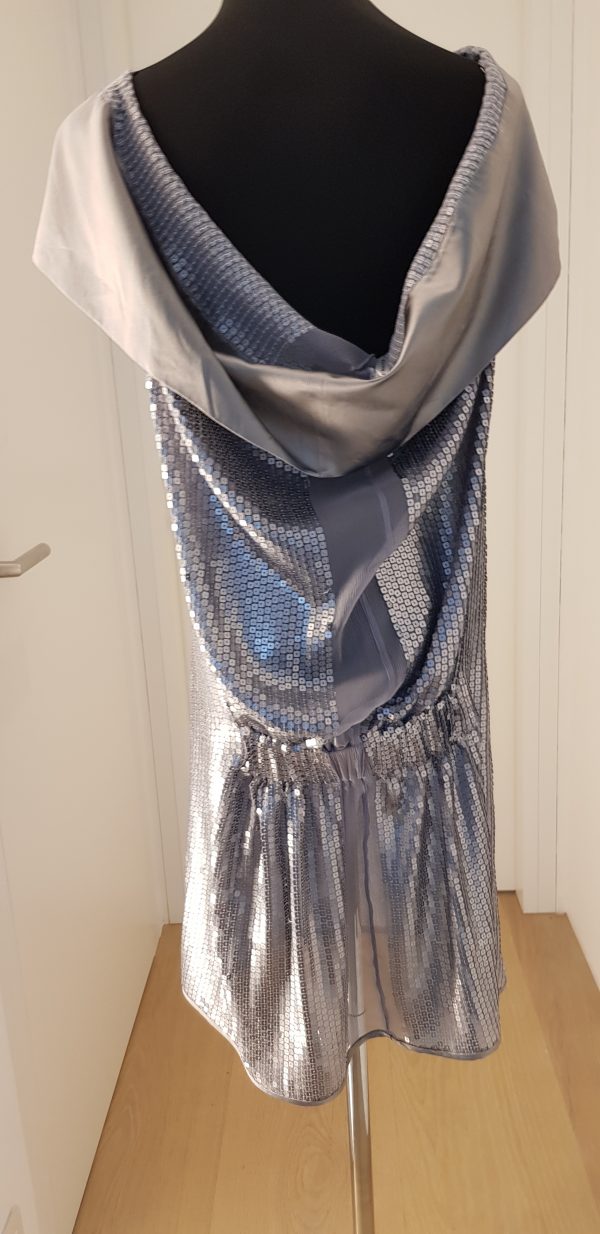 Silbernes Paillettenkleid mit extrem breitem silbernen Schalkragen, blaues Ornament vorne