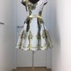 Kurzes Cocktailkleid mit weiß-goldenem großen Ornamentmuster, schmaler Gürtel, V-Ausschnitt und weit schwingendem Rock