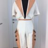 Winterweißer knielanger Jumpsuit mit hellen Naturlederaufschlägen und seitlichen Taschen, Rücken offen mit Spangen gehalten