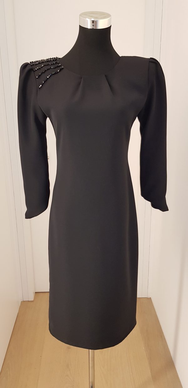 Schlichtes, schwarzes Cocktailkleid mit Strass auf der rechten Schulter, asymmetrischer Ärmelabschluss, knielang, breite Schultern