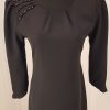 Schlichtes, schwarzes Cocktailkleid mit Strass auf der rechten Schulter, asymmetrischer Ärmelabschluss, knielang, breite Schultern