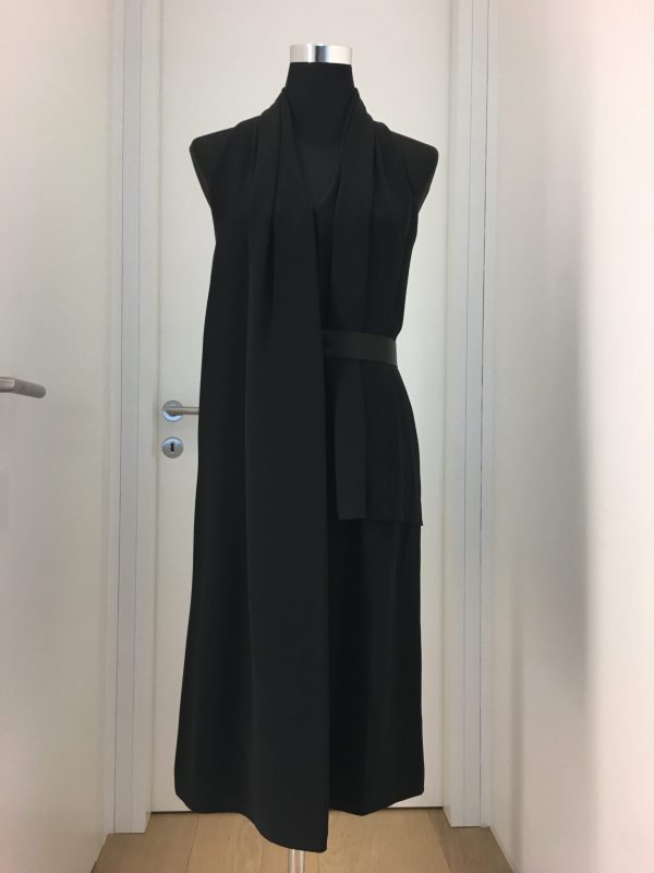 Asymmetrisches schwarzes Gürtelkleid ohne Ärmel, vorne ein langer freischwingender Faltenteil