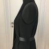 Asymmetrisches schwarzes Gürtelkleid ohne Ärmel, vorne ein langer freischwingender Faltenteil